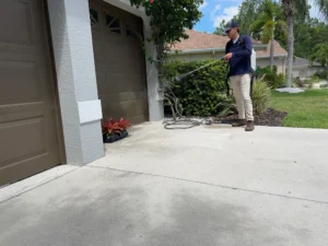 Professional pest control technician spraying treatment around home exterior and landscaping in Florida