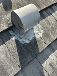 Roof vent cap sealed with wire mesh and screws for rodent exclusion on tile roof