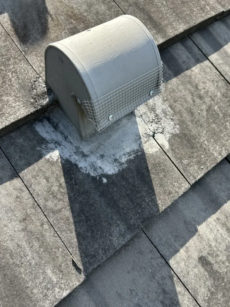 Roof vent cap sealed with wire mesh and screws for rodent exclusion on tile roof
