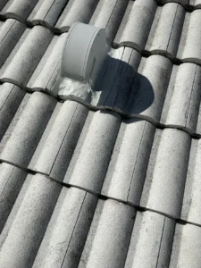 Metal roof vent with sealed flashing base on gray concrete barrel tile roof